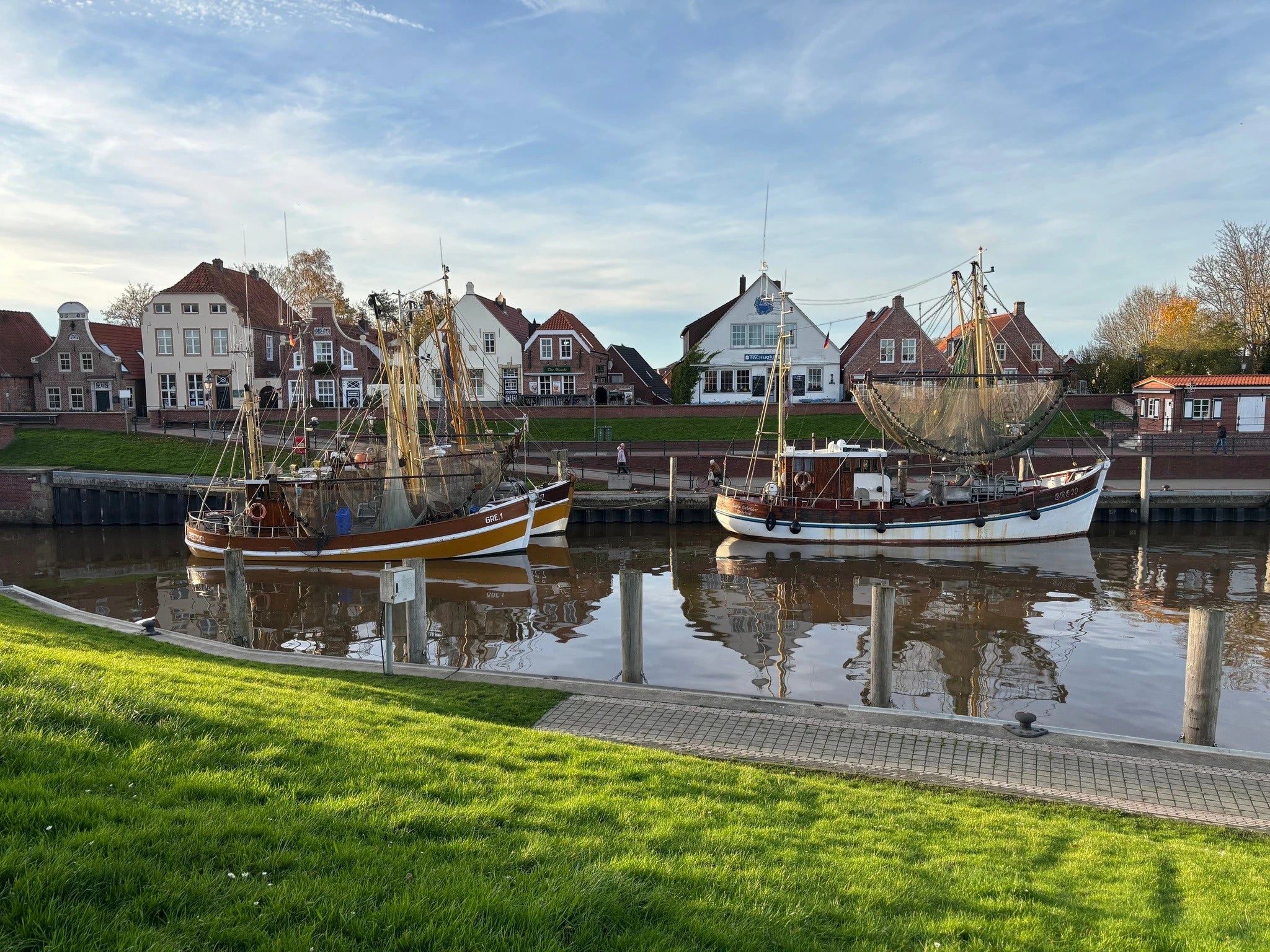 Historischer Kutterhafen in Greetsiel mit traditionellen Krabbenkuttern vor alten Packhäusern als Ausflugstipp im Nordseeurlaub.